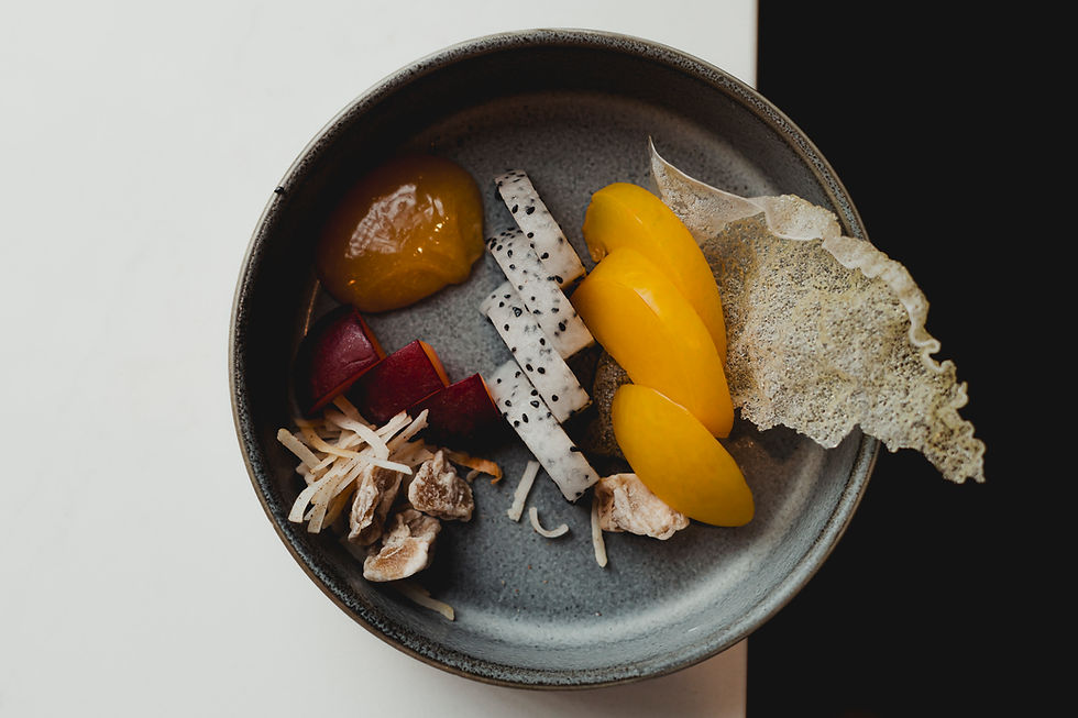 Overhead shot of composed dessert with yellow fruit and dragonfruit