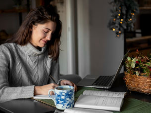 An adult student working on a laptop at home, representing flexible online learning in a bachelor’s degree in liberal studies program.
