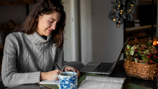 An adult student working on a laptop at home, representing flexible online learning in a bachelor’s degree in liberal studies program.