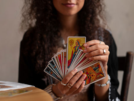 A hand holding a custom playing card deck with personalized artwork, surrounded by packaging and printing tools.