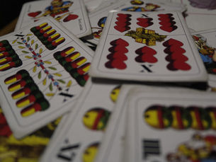 Close-up of personalized playing cards with custom back design on a wooden table.