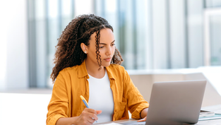 An adult student studying on a laptop, representing flexible online learning in a master’s degree in public health program