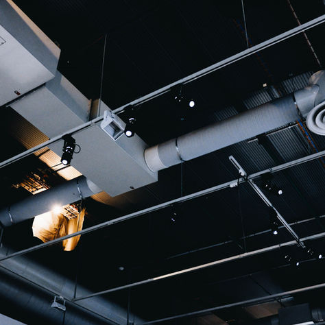 Exposed commercial HVAC ductwork and ventilation system in a building ceiling, illustrating commercial indoor air quality management and airflow distribution.