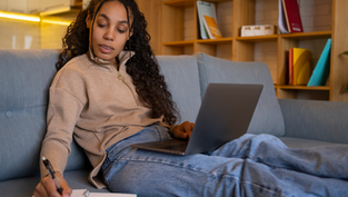 Young woman studying on her laptop for an online degree through LAPU’s flexible learning platform.