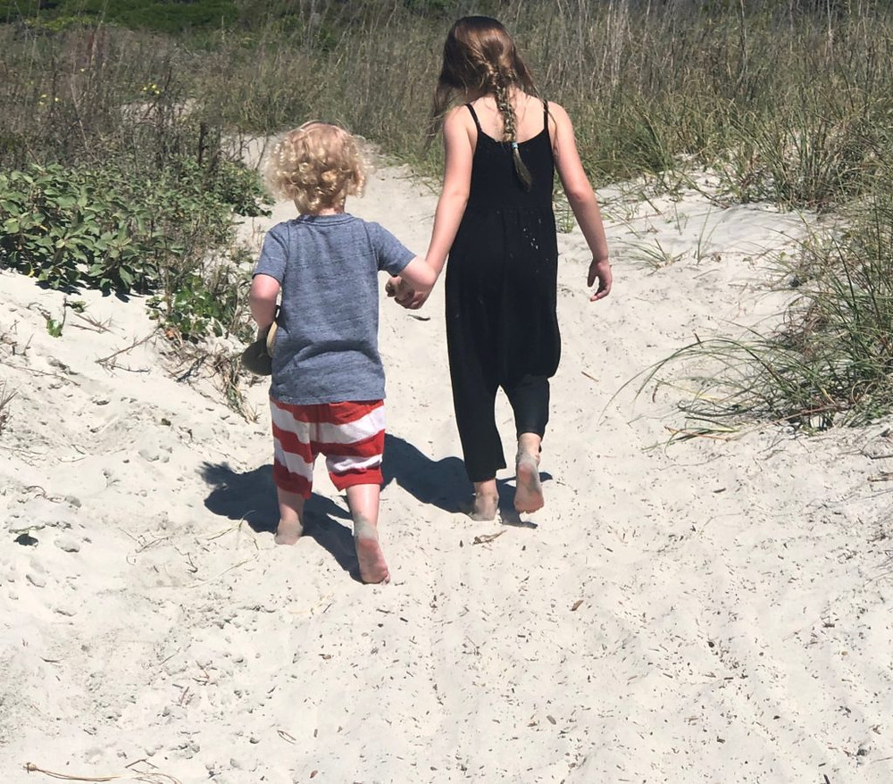kids walking along the beach hand in hand
