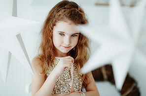 Kind in einem weißen Raum mit EWeihnachtssternen