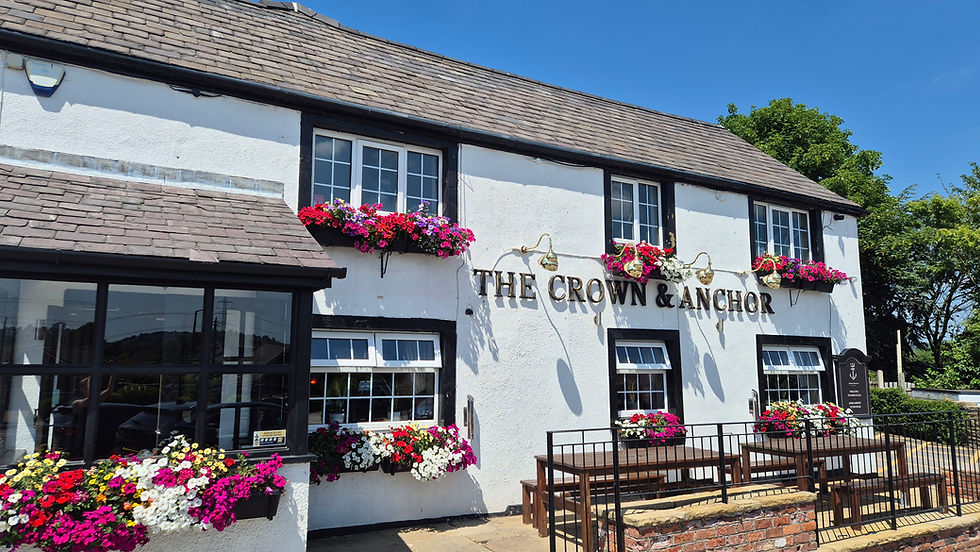 The Crown and Anchor Barugh Green, Barnsley. Blue sky sunny day traditional pub with bright flower windon boxes and outside seating