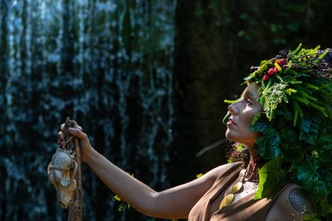 Madre Natura sicura ascolta il mondo muovesi attorno a se, sente l'acqua della csacata alle sue spalle e fiera impugna il bastone. ha un volto fiero ed un copricapo ricco di foglie e frutti rossi bagnata da una calda luce sul viso e sul petto