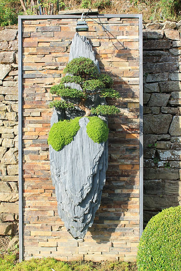 gravity , sculpture unique de 300 kilos sculptéee par arnaud Desbois ,sculpteur de paysages et suspendues à un mur moderne, elle est sculptée en schiste et ornée d un orme de chine agé de 30 ans