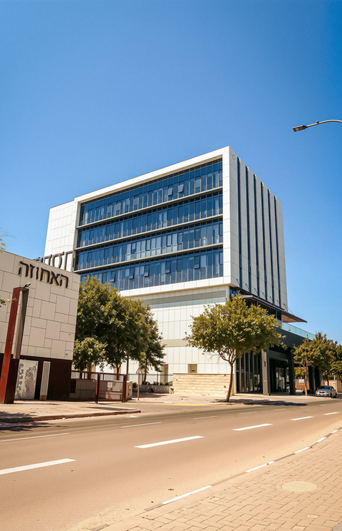 The building where Dr. Pearl Family Dental Care is located, in Modi'in. Modern building with glass facade, street, and clear sky