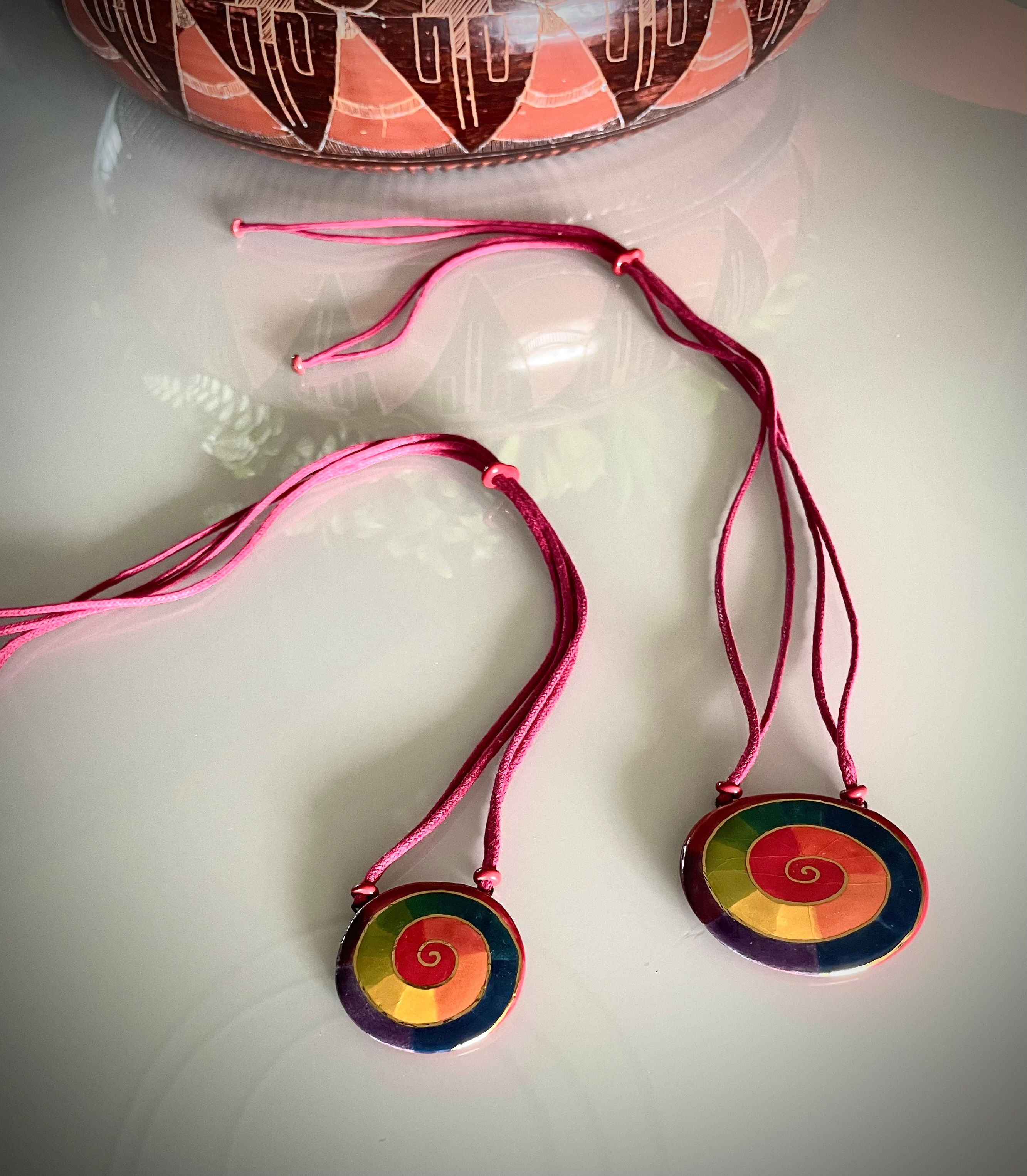 Colar medalha oval vermelho.