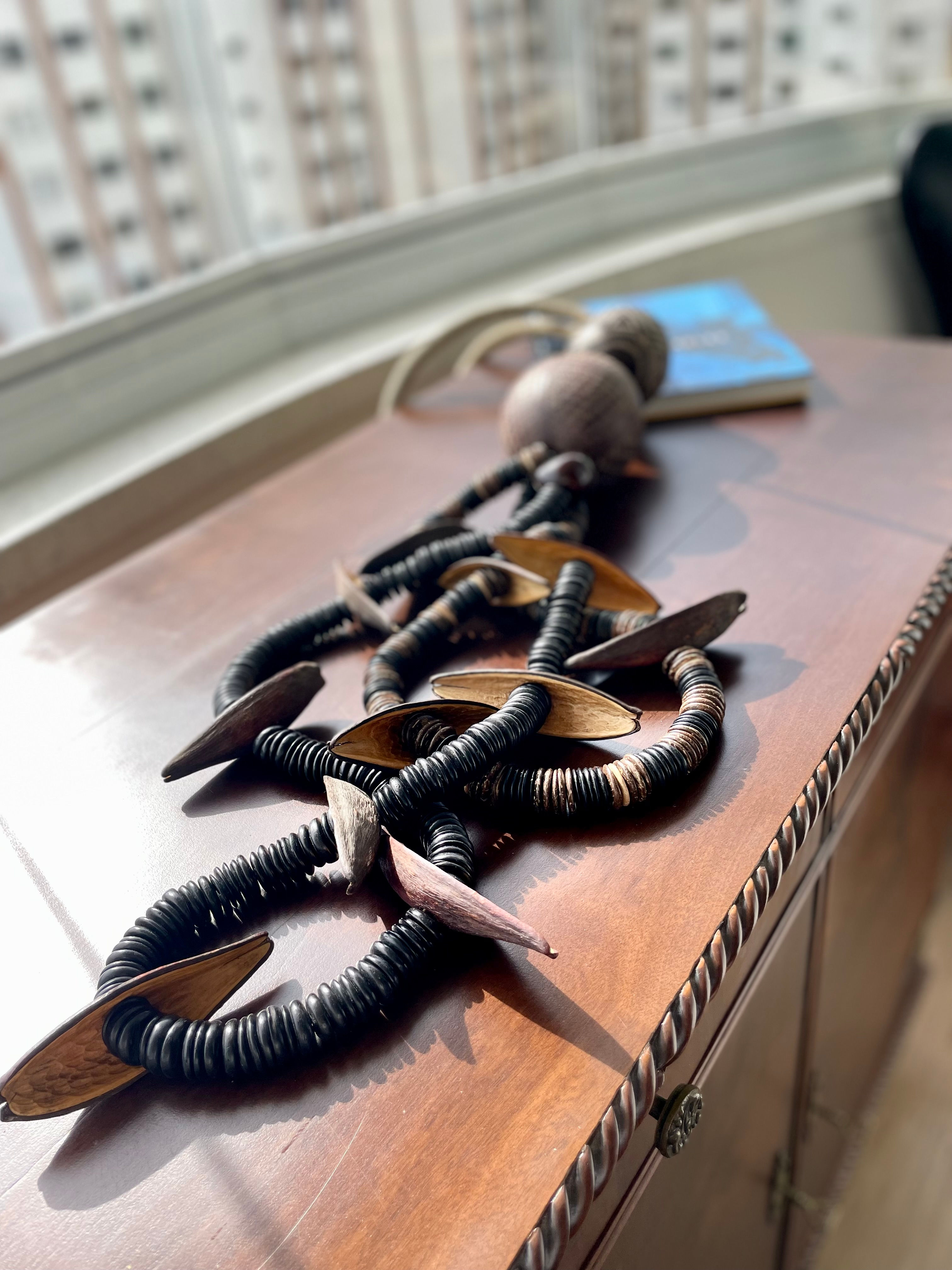 Colar de mesa ou parede feito com discos de coco, tucumã e cabaças.