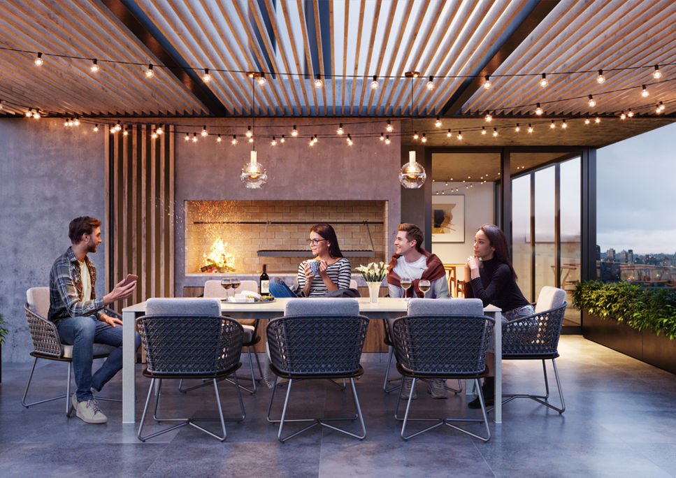 Terraza del edificio Arbet Soho con comedor al aire libre y vista a Montevideo al atardecer.