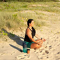 Picture of Kate doing breathwork exercises on the beach