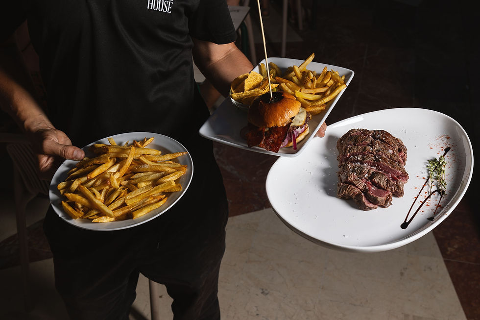 Camarero sirviendo carne a la parrilla, hamburguesa gourmet y patatas fritas caseras en Bar América, La Carihuela, Torremolinos