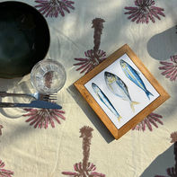 Fish trilogy ceramic tile, in a wooden frame, displayed on a dining table