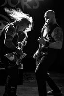 Zwei Musiker spielen Gitarre bei intensivem Bühnenauftritt