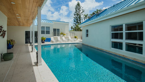 a large swimming pool is surrounded by white buildings