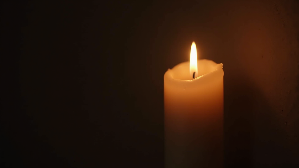 Close-up view of a softly glowing candle flame in a dark room