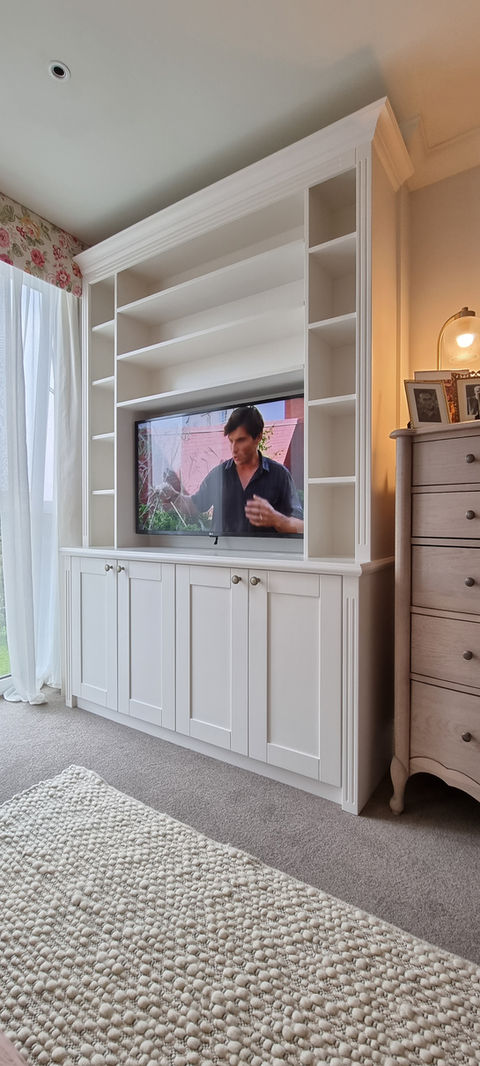 White TV unit with low level storage and exposed shelves.