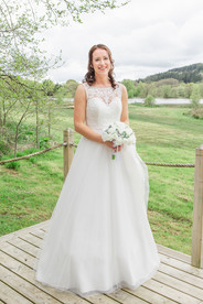 bride poses for sylen lakes wedding photographer outside on decking