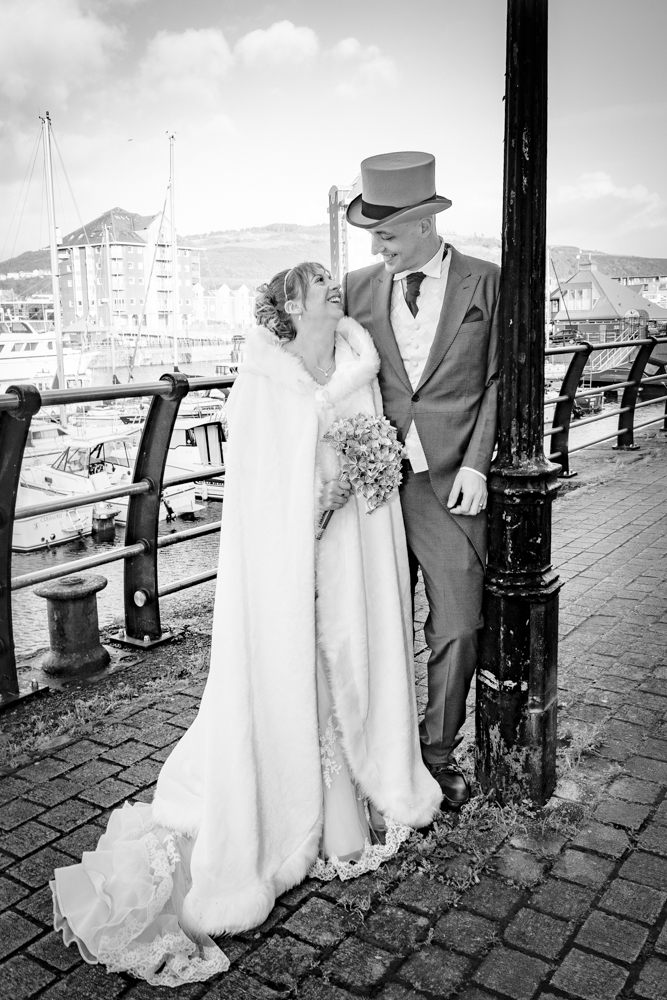 bride and groom pose for a photograph in Swansea marina