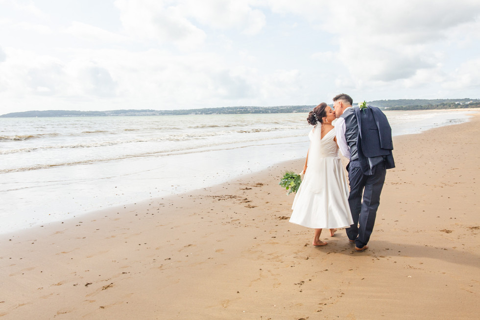 wedding photography of bride and groom on swansea bay with mumbles in the background
