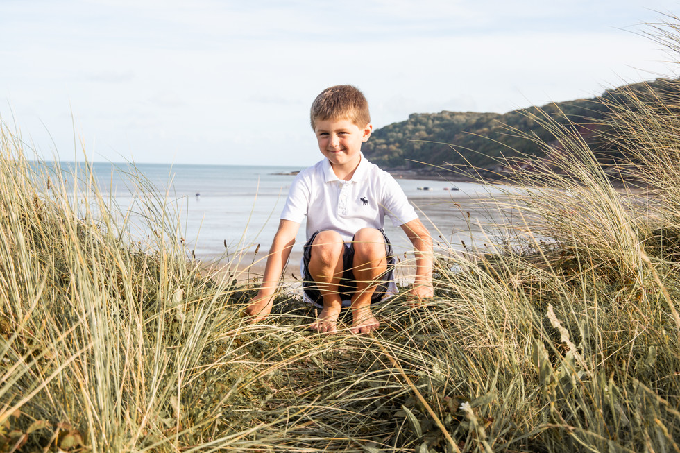 boy poses happily in the dunes at oxwich bay