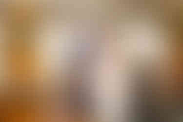 groom looks happily at bride as he puts a Swansea wedding ring on her finger