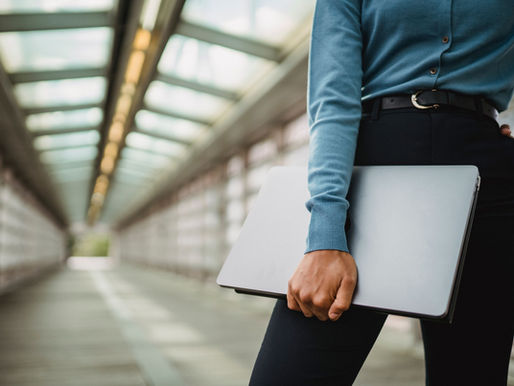 Woman carrying a laptop in a train station