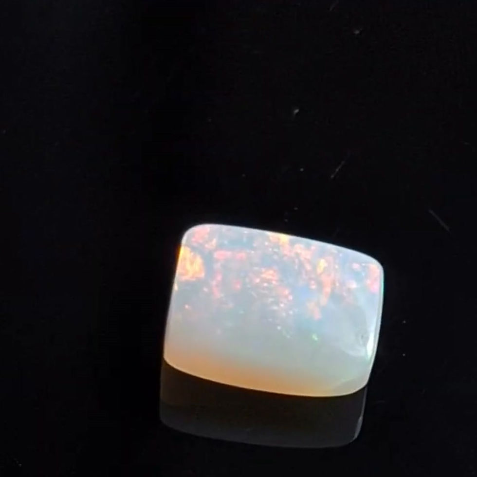 Natural 1ct Lightning Ridge opal with a soft milky body tone and peach, pink-orange, yellow and green flashes side view