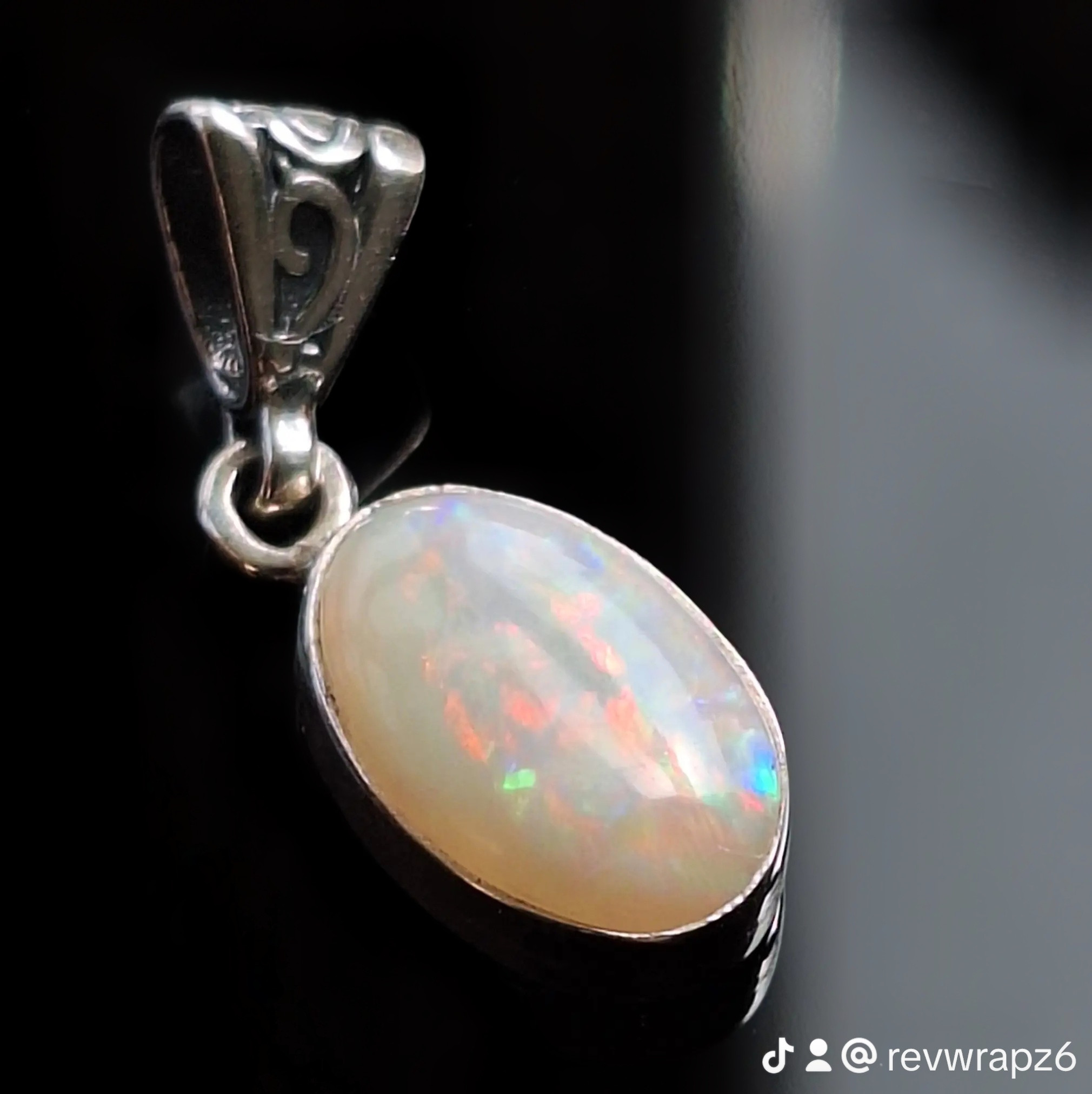 Coober Pedy CP Olympic solid opal bezel pendant with vibrant red, green, and blue fire, right view.
