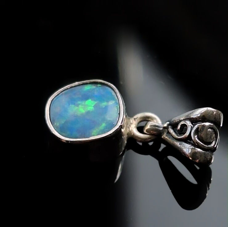 Side view of sky blue Lightning Ridge opal doublet pendant in sterling silver