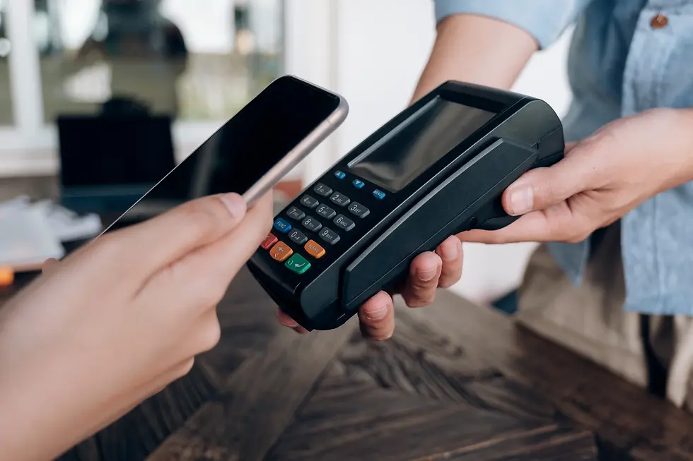 Pagamento por aproximação com smartphone sendo realizado em uma maquininha de cartão, com foco nas mãos e no dispositivo em ambiente interno. 