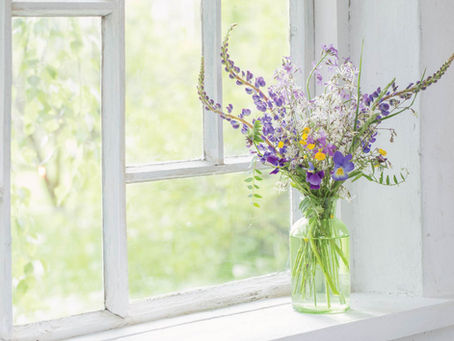 Vase of cut flowers on a shady window sill