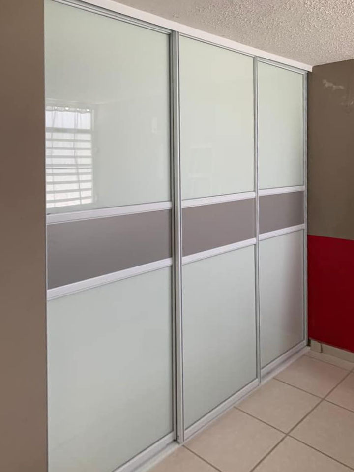 Puertas de closet en aluminio y vidrio. Franja de aluminio en el centro de cada puerta.