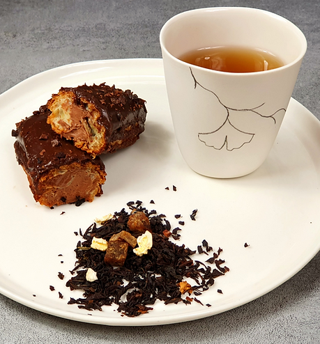 Assiette avec Tasse de thé et éclair au chocolat