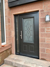 Black residential door with decorative glass panel