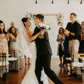 bride and groom embrace as they walk down the aisle 