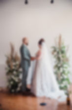 bride and groom near free-standing floral installations for woodland inspired wedding