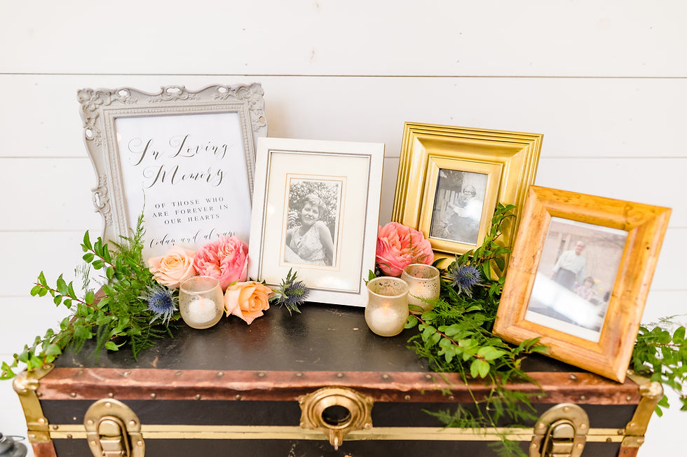 memory table consisting of vintage black steamer trunk and personal photos of family who has passed. A loving tribute.