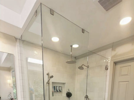 Installer measuring a frameless glass shower door in a Metro Atlanta bathroom