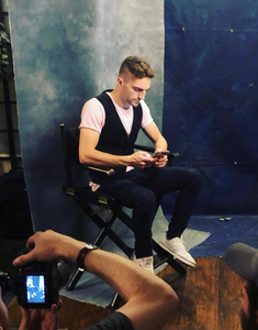 Oleh Simcha Brodsky being photographed while sitting in a chair