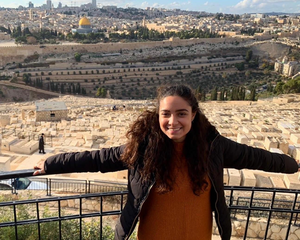 Olah Rosie Tourgeman leaning on a fence overlooking the Mount of Olives cemetery