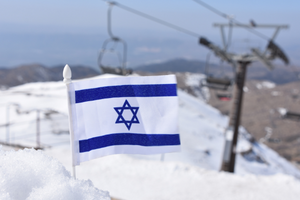 An Israeli flag in a pile of snow on Mount Hermon after a snowstorm