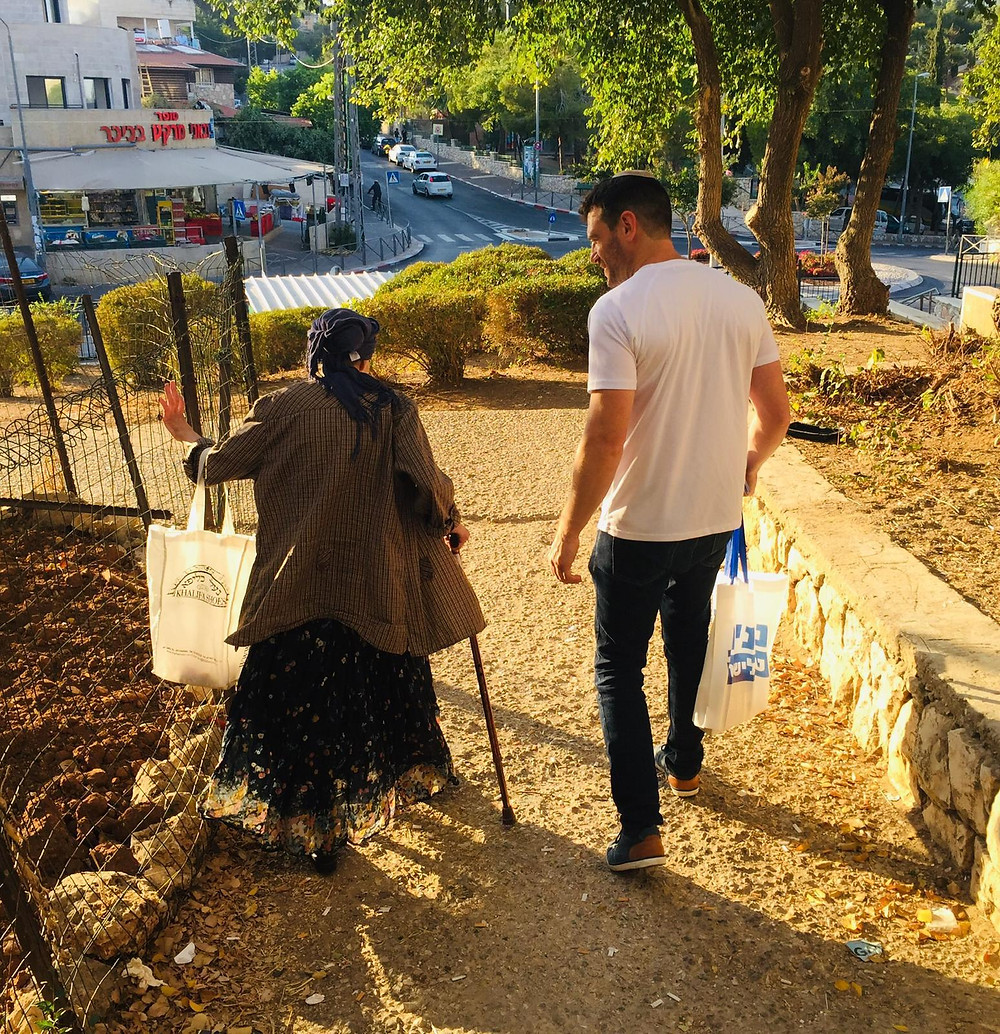 A young man accompanies an older woman to vote in the Israeli elections