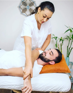 Olah Yudith Guttman giving stretching the arm of a male client