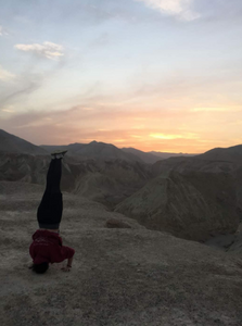 #Meet_the_Oleh, Maddie De Silva, doing a head stand on top of a mountain in the desert at sunrise