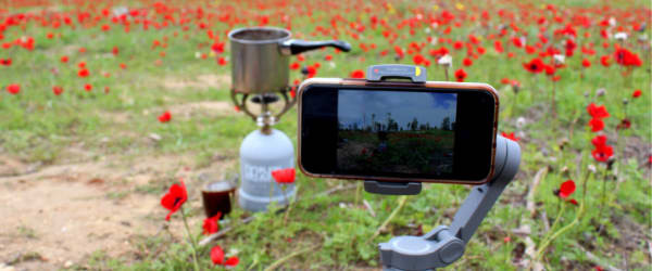 A pakal kafe set up in a field of red flowers with a camera set up in front