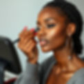 a beautiful black woman applying make-up.jpg